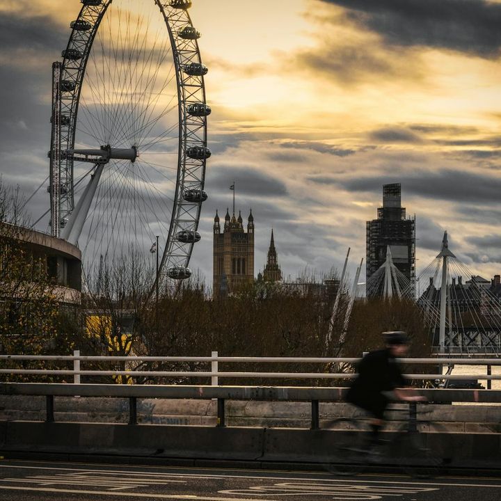 The London Eye and the Houses of Parliament at sunset, seen from the river.